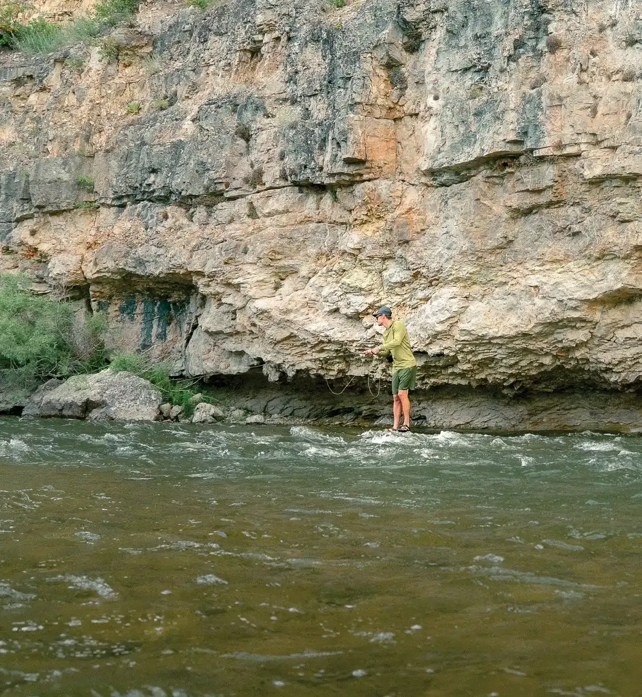 A fisherman watches life move beneath the surface of the Smith River