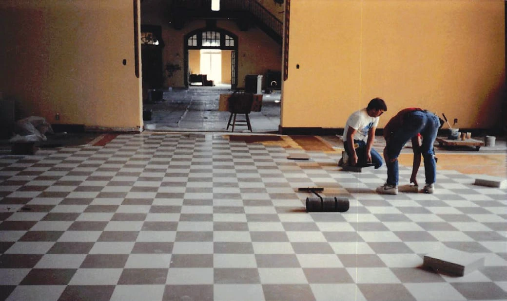 Workers remodeling the checkered floor at the Gallatin Gateway Inn