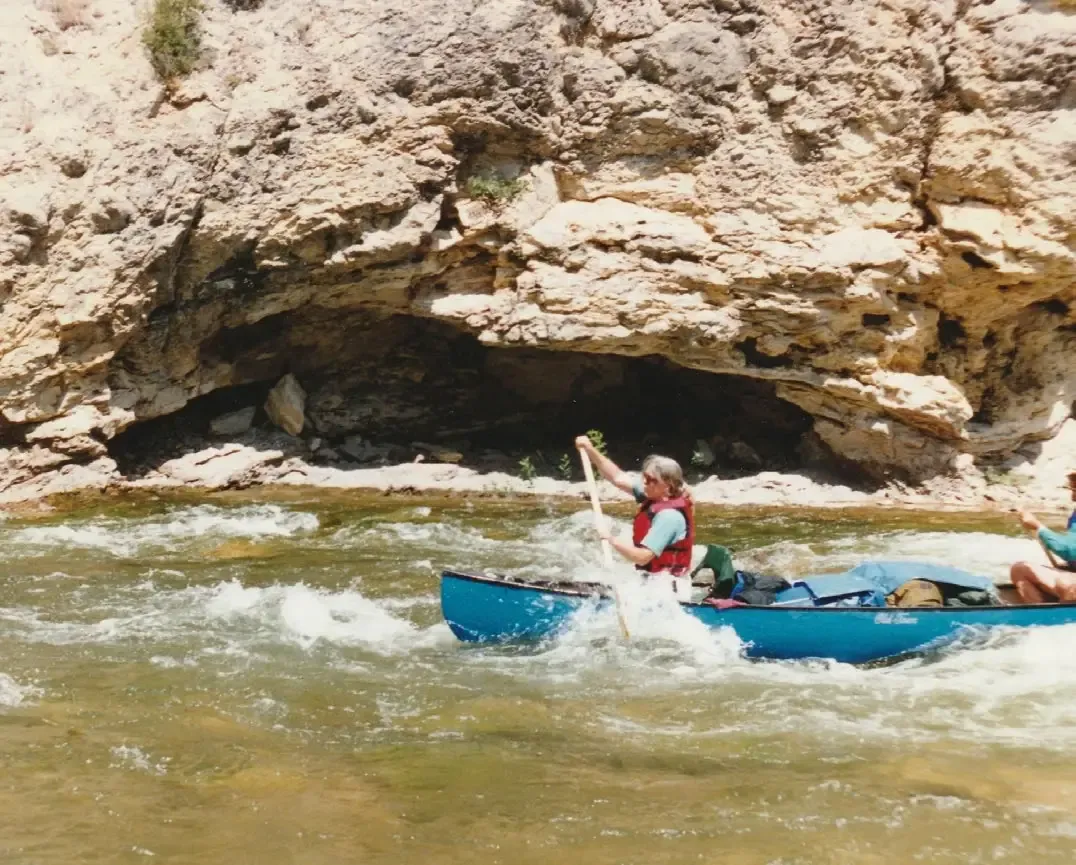 Jeanne-Marie Souvigney paddling a raft through whitewater