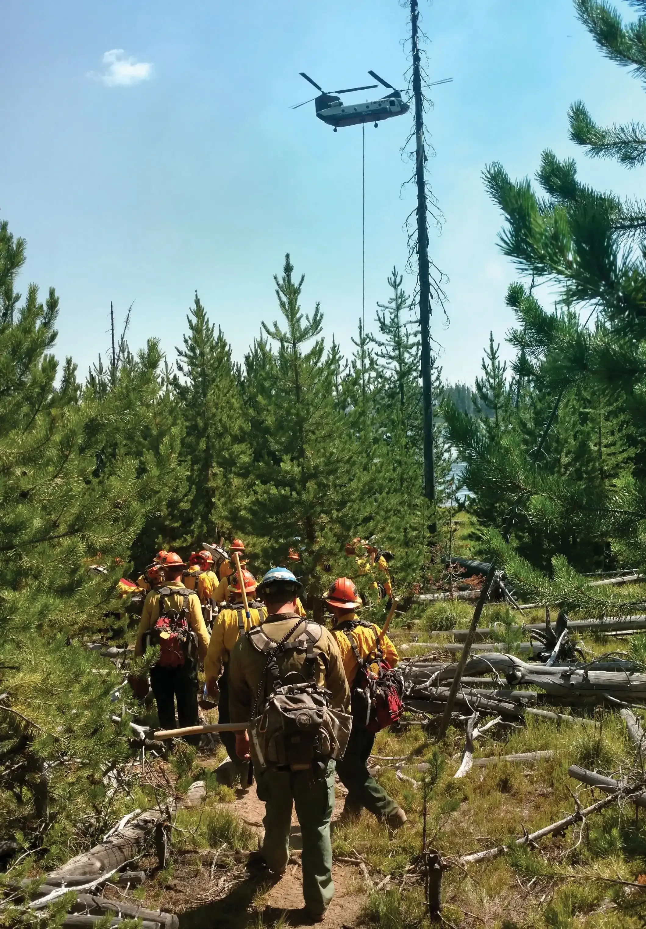 Men to Match Our Mountains: How Montana turns inmates into wildland firefighters 2 The Montana inmate fire crew walking toward the fire line as a helicopter passes overhead